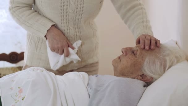 Velha mulher enrugada deitada na cama: assistência, doença, doença, doença — Vídeo de Stock