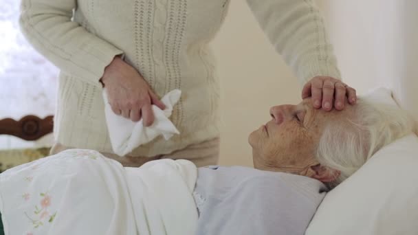 Old wrinkled woman laying in bed: assistance, illness, sickness, disease — Stock Video