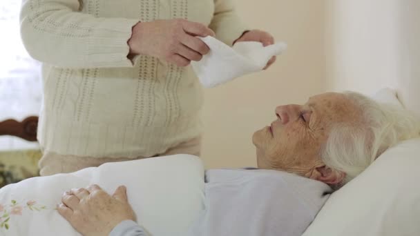 Стара зморщена жінка лежить у ліжку: допомога, хвороба, хвороба, хвороба — стокове відео
