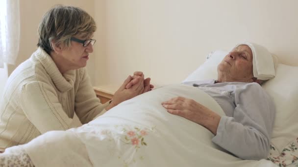 Old wrinkled woman laying in bed: assistance, illness, sickness, disease — Stock Video
