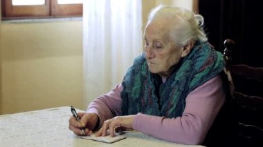 yaşlı kadın küçük not etmek üstünde yazıyor: kalem, kağıt, eski, eski, notlar, alır