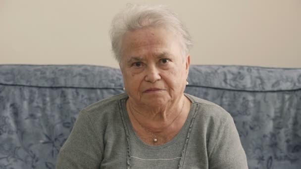 Oude depressieve vrouw zitten op de staart van de Bank op de camera — Stockvideo