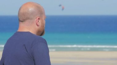 adam endişeli ve endişeli endişeyle deniz kıyısı üzerinde bir sigara içiyor