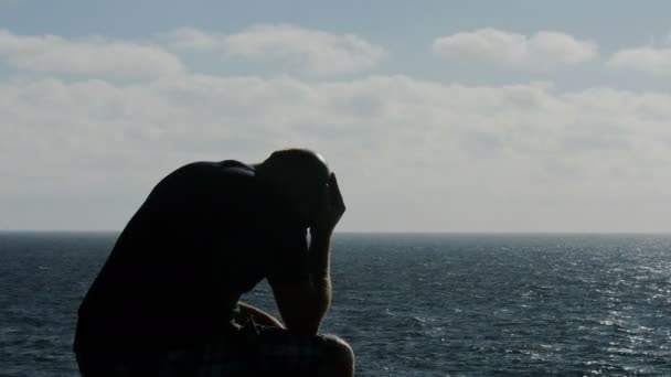 O homem sozinho à beira-mar está desesperado pela morte da mãe. — Vídeo de Stock