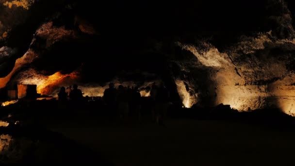 Cueva de Los Verdes - crowd of people walking in the darkness of the cave — Stock Video