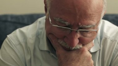  Yalnız kanepede oturan endişeli yaşlı adam