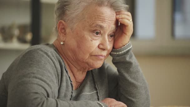 Pensativa velha mulher segurou a cabeça com a mão — Vídeo de Stock