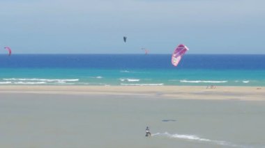Fuerteventura-insanlar rüzgarlı bir günde güzel bir plajda sörf uçurtma