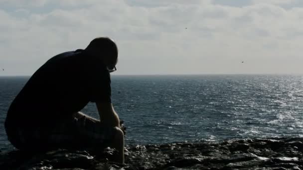Portrait of depressed guy thinks about suicide in front of the sea — ストック動画