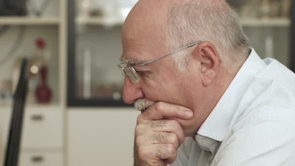 Ανησυχούν ηλικιωμένος άνδρας κάθεται μόνος στον καναπέ — Αρχείο Βίντεο