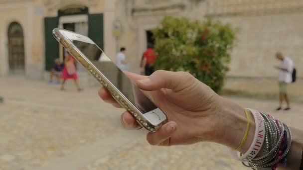 Young woman's hand typing a message on the street — ストック動画