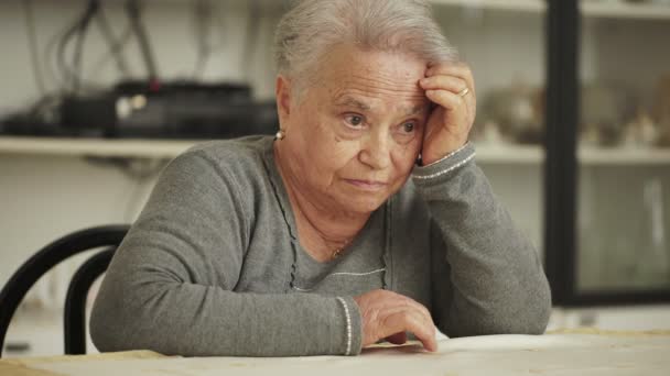 Pensativo anciana sentarse en su cocina — Vídeos de Stock