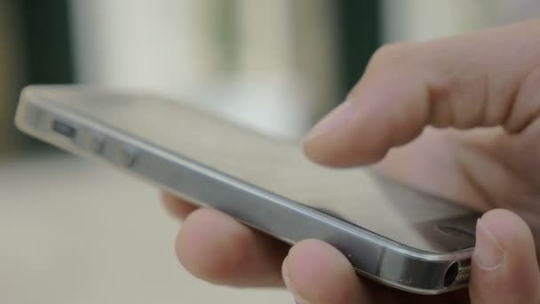 Hombre joven mano está utilizando el teléfono inteligente al aire libre — Vídeo de stock