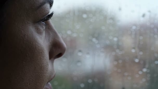 うつ病悲しみ窓の女性は雨滴がガラスの上に滑るのを見る — ストック動画