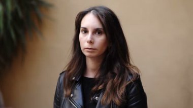 Gençlik, kendine güven. Ciddi bir kadın kameraya bakıp neşeleniyor ve gülüyor.