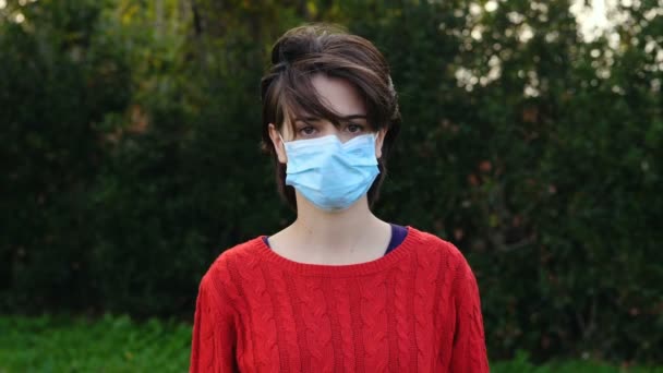 科罗纳病毒 在多风的天气里 年轻女子在公园里戴着口罩 — 图库视频影像