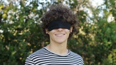 Eğlence, neşe - genç adam komik bir şekilde maske takıyor, gözlerinin üstüne.