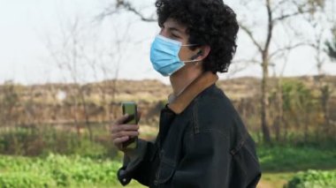 Maskeyle dans eder - genç adam cep telefonunda müzik dinler ve dans eder