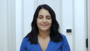 Güven, umut - ciddi kadın ifadesini değiştirir ve kameraya gülümser.