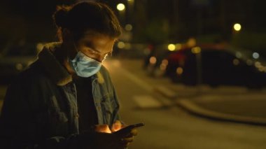 Telefonla yazı yazan adam nefes almak için maskesini çıkartıyor.