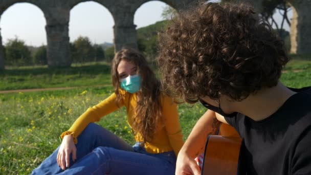 Parque Con Máscara Joven Romántico Toca Guitarra Para Novia — Vídeos de Stock