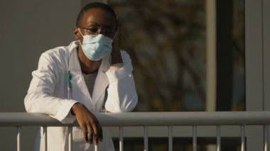 Hastaneden kaçmak - Duraklama sırasında güneşin altında yorgun siyah doktor