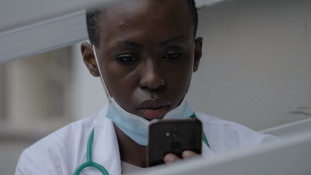 Πανδημία 2020 Κουρασμένος Μαύρος Γιατρός Ελέγχει Τηλέφωνό Της Μια Στιγμή — Αρχείο Βίντεο