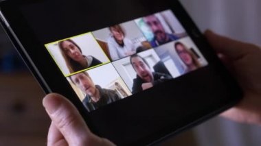 Kadın elleri videoda konuştuğu tableti tutar.