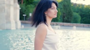 Güzel, genç, güzel kadın kendine döner ve kameraya bakar.