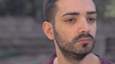 Düşünceler, endişeler, ciddi bir adam başını çevirip kameraya bakıyor.