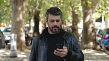 Teknoloji, iletişim genç adam telefonundan bir mesaj okuyor ve gülümsüyor. 