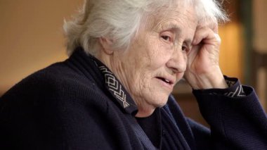 Oturmuş düşünceli yaşlı kadın