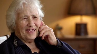 Yaşlı kadın oğluyla telefonda konuşuyor.