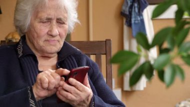 Yaşlı bayan akıllı telefonlu mesajlar atıyor.