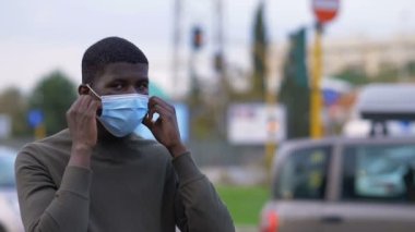 Cerrahi maske takan genç bir Afrikalı.