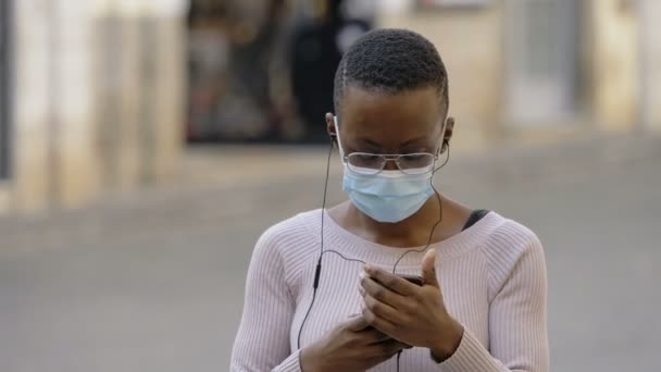 Dans Met Masker Zwarte Vrouw Zet Oortelefoon Luisteren Naar Muziek — Stockvideo