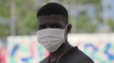 Cerrahi maske takan genç bir Afrikalı.