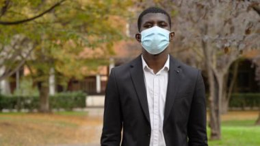 Cerrahi maske takan genç bir Afrikalı.