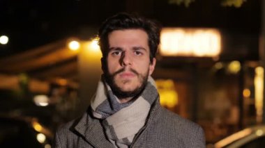 Gençlik, kendine güven - ciddi adam ifadesini değiştirir ve kameraya gülümser - gece