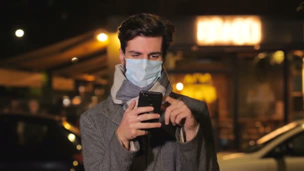 Coronavirus Man Met Masker Types Mobiele Telefoon Staart Naar Camera — Stockvideo