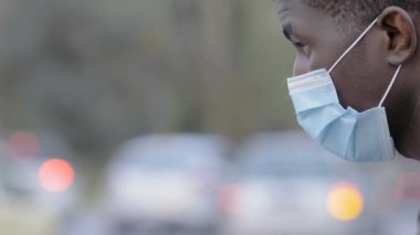 Cerrahi maske takan genç bir Afrikalı.