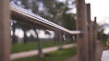 Egzersiz ekipmanlarını sterilize et. Adamın eli bardaki dezenfektanı uzatıyor.