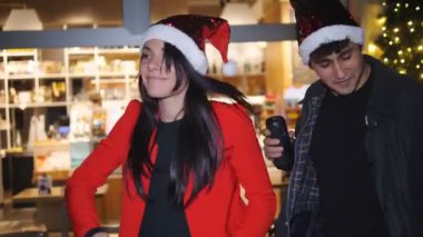 Gençlik, teknoloji - genç çift Noel 'de telefonda müzik dinler ve dans ederler.