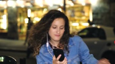 Gençlik, teknoloji - tasasız kız cep telefonunda müzik dinler ve dans eder