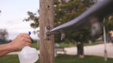 Hijyen, salgın hastalık. Adamın eli parktaki bara dezenfektan sıkar.