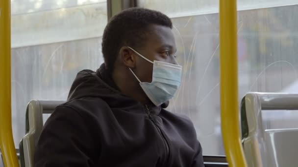 Coronavirus Allvarlig Svart Man Med Mask Bussen Tittar Genom Fönstret — Stockvideo