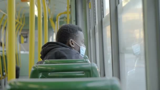 社会的距離 ほとんど空のバスに座ってマスクを持つ黒人男性 — ストック動画