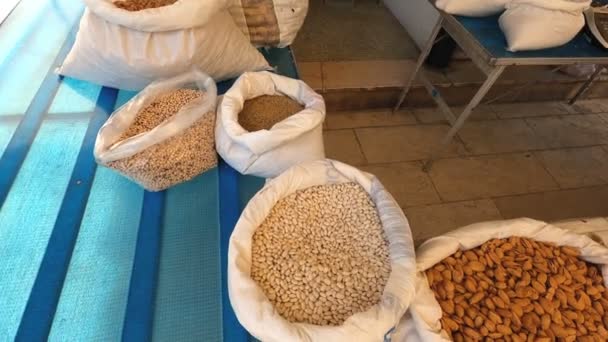 市場の屋台の白い豆でいっぱいの袋の上に定常カム — ストック動画