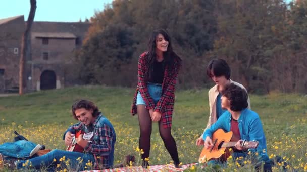 Веселі Молоді Люди Парку Грають Гітарі Їхні Друзі Танцюють — стокове відео