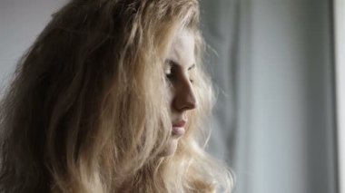 Sorunlar, düşünceler. Üzgün kadın dönüp kameraya ciddi ciddi bakıyor.